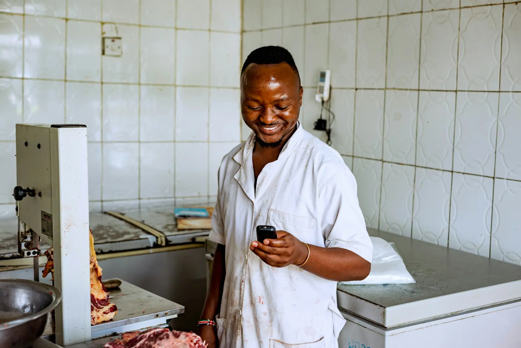 Food business owner checking an order on his phone in his kitchen